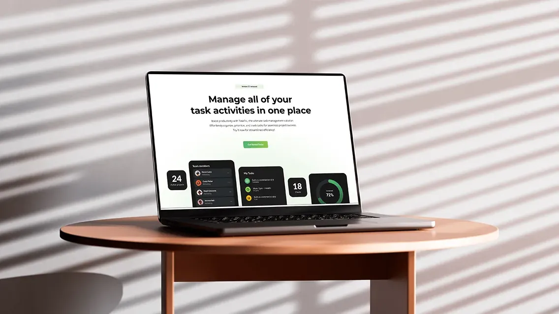 The Plan Pixel landing page on a laptop standing on a round wooden table.